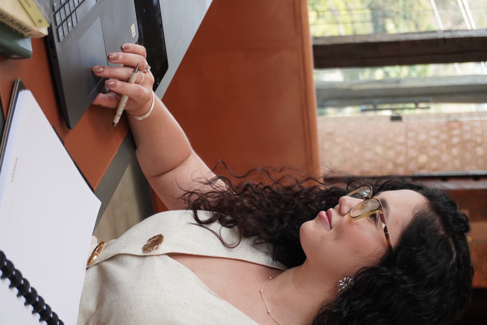 Mayara Dias, psicóloga, trabalhando no notebook em seu consultório