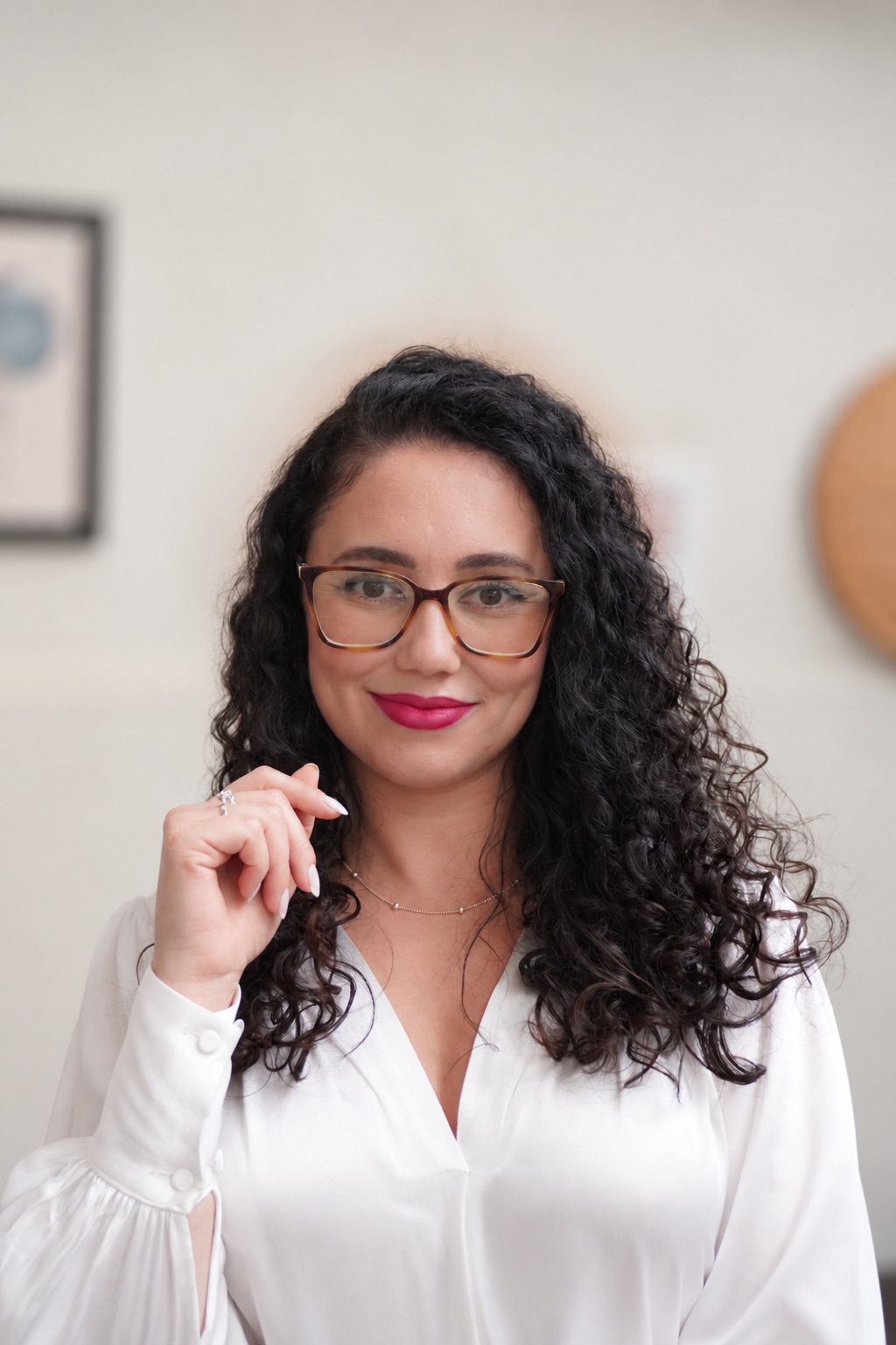 Retrato de Mayara Dias sorrindo, ajeitando o cabelo